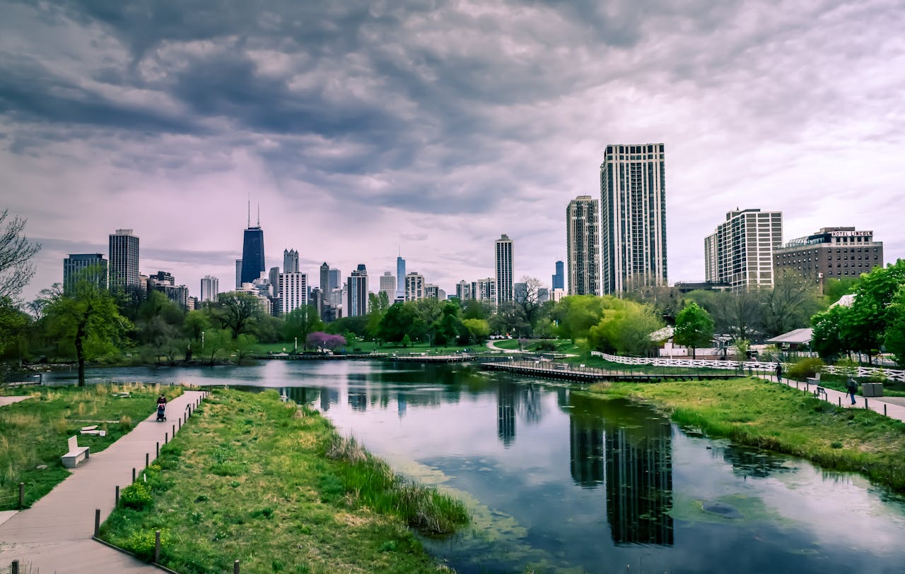 hero-gallery-02 Dramatic view of Chicago skyline with reflections over Lincoln Park Lagoon on a cloudy day.